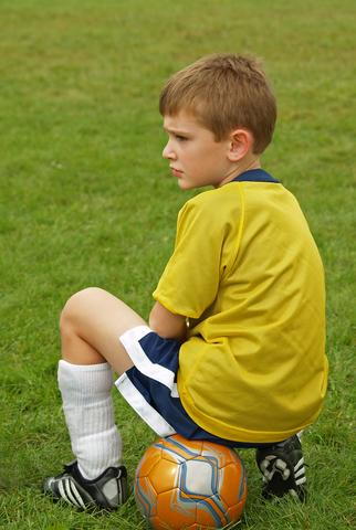 A boy sitting on a football