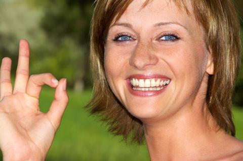 A women's making okay sign with her hand