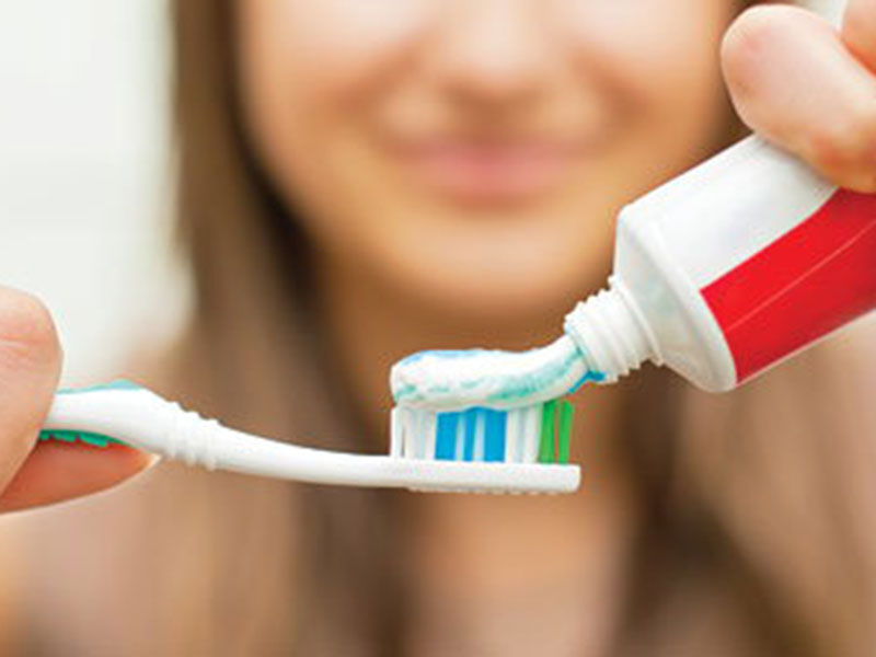 A women taking a toothpaste